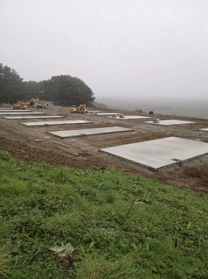Concrete pads on a new site, seen from the bank