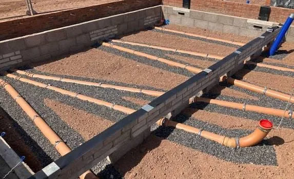Drainage pipes laid in gravel inside new footings